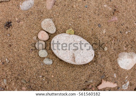 trace feet made of a pebble stone close up on the sea sand desert surface texture backdrop.