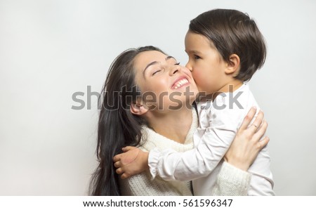 little girl  kissing her mother Royalty-Free Stock Photo #561596347