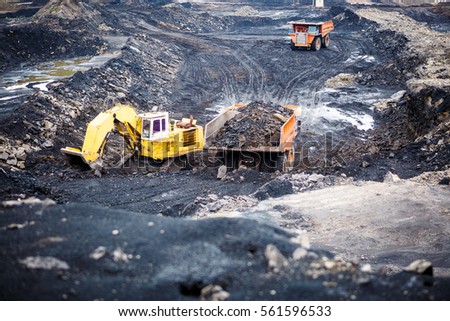 Mining dump trucks working in Lignite coalmine Royalty-Free Stock Photo #561596533