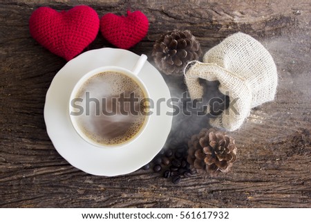 Coffee cup which smoke with red heart on wooden floor 