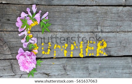 the word "summer" is lined with flower petals on the old boards, sunny summer day, flower petals on the wooden background