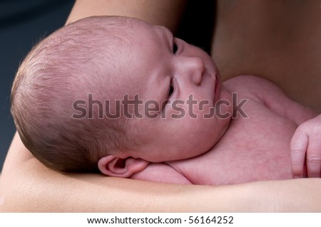 Portrait of newborn in his mother arms, very peaceful.