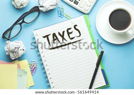 Text taxes  on the white paper with coffee, calculator and coffee on blue table
