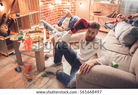 Guys are sleeping in messy room after having a party at home
