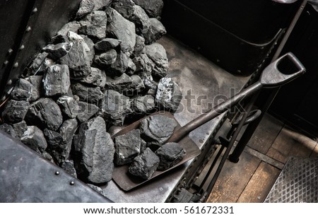 Shovel and coal in historic steam locomotive. Industrial revolution theme. Royalty-Free Stock Photo #561672331