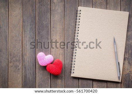 notebook with pencil add Heart Knitting on wooden table, Valentine background. Vintage picture tone