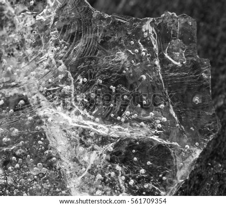 Close up of air bubbles trapped in ice, monochrome