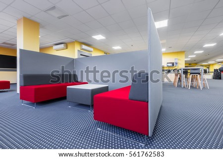 Library lounge area with red sofa, table and grey partition