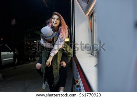 Young longboard couple having fun outdoors at night