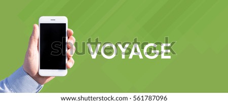 Smart phone in hand front of green background and written VOYAGE