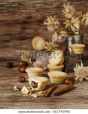 small round Christmas cakes stuffed with nuts and cinnamon on a brown wooden table, selective focus, space for text