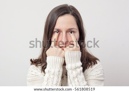 Young girl with long hair holding her fingers in front of eyes. She does not want or can not watch.