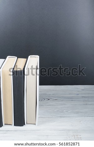 Open black and White books on wooden table, black board background. Back to school. Education business concept