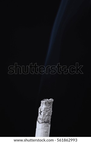 Hand with smoking cigaret. Isolated over black.