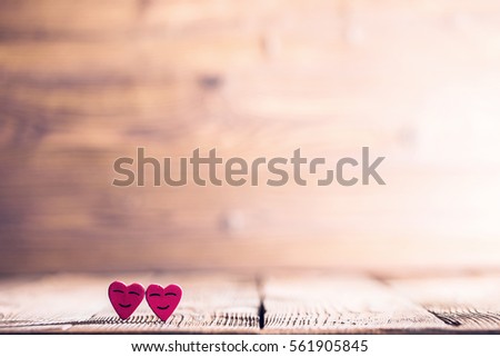 Two pink happy smiling hearts on wooden background