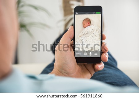 Close-up Of Person Looking At The Videostream Of His Baby