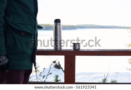 Part of tourist in forest trip. Relax and rest time with pot of hot tea with winter snowy landscape background. Copy space for advertising travel goods or tourism stuff