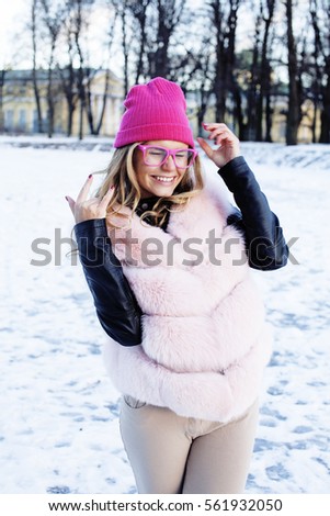 young pretty teenage hipster girl outdoor in winter snow park having fun drinking coffee, warming up happy smiling, lifestyle people concept
