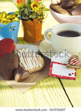 Heart shaped cookies (big and small as couple), cup of coffee, bouquet of flowers decoration. sunny morning. Romantic breakfast or Valentine's Day Breakfast. Toned image
