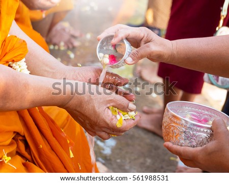 monk hand waiting for water from people represent celebrating thai new year Royalty-Free Stock Photo #561988531