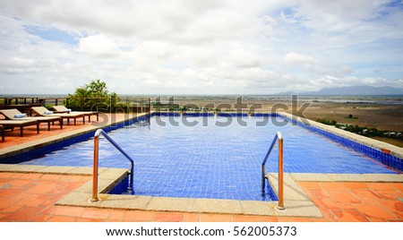 Relaxing chairs at beautiful swimming pool in the countryside of southern Vietnam.