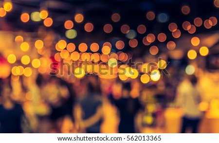 vintage tone blur image of food stall at night festival with bokeh for background usage . Royalty-Free Stock Photo #562013365