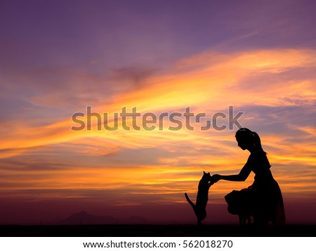 Silhouette of girl plays with her cat on the roof