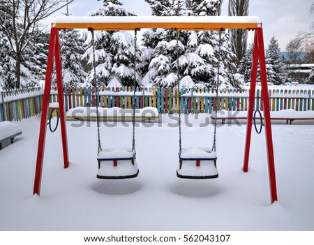 Children's playground covered with snow in winter