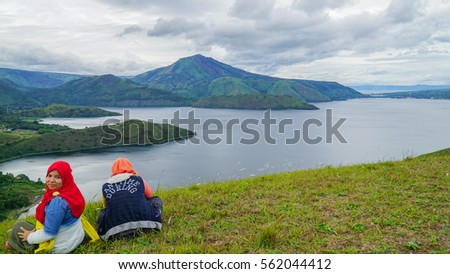 Two girls on top of a hill at Samosir Island, with the famous Lake Toba/ Danau Toba view