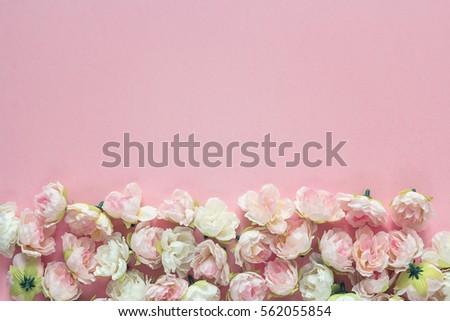 Little roses flowers on pink background with empty space for text. Top view with copy space