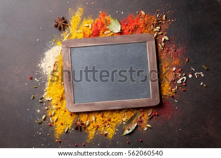 Chalkboard for your text over various spices on stone table. Top view with copy space 