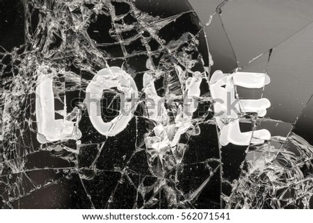 Word LOVE on a black cracked glass.