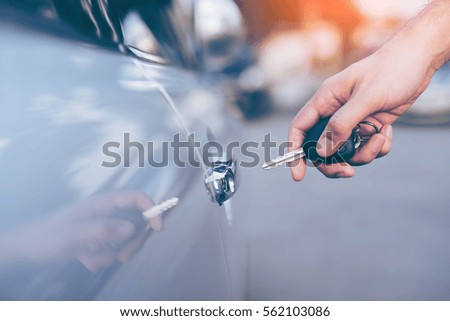 Men's hand using key unlock doors car 