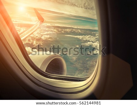 Beautiful view from  porthole of airplane on sky with clouds under sun light. View from at sunny day.