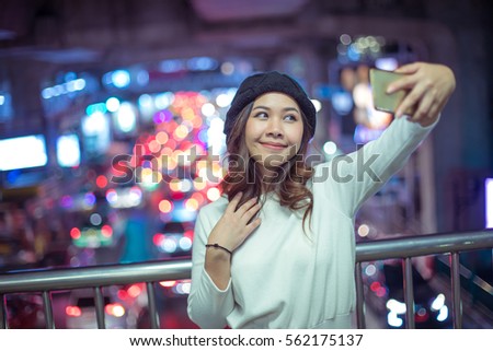 Happy asian woman taking selfie joyful and happy smiling at night