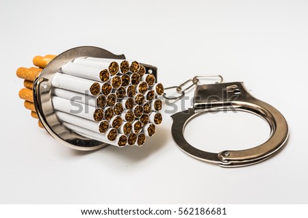 Cigarettes and handcuffs - smoking addiction concept on white background