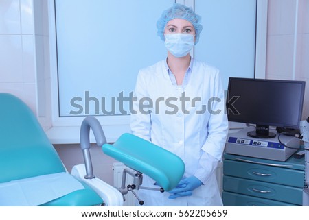 Gynecologist in room with chair at modern hospital