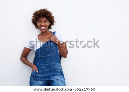 Portrait of smiling african woman in overalls against white isolated background