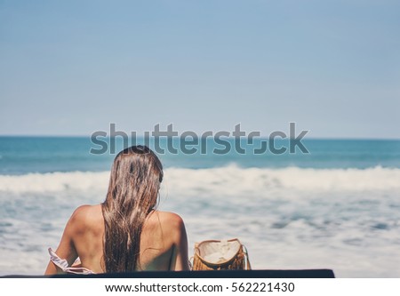 Beautiful young woman relaxing by the sea                               
