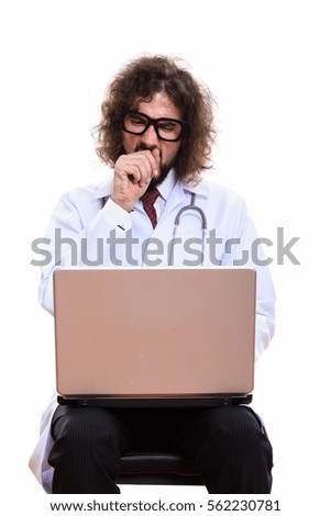 Studio shot of tired man doctor using laptop while yawning