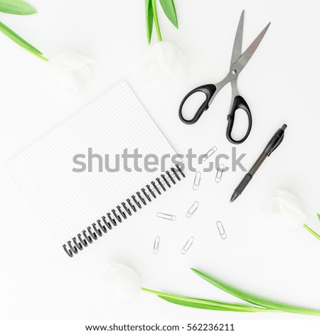 Feminini desk workspace with flowers, notebook, scissors, pen and clips isolated on white background. flat lay, top view