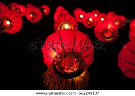 Happy chinese new year concept: traditional red paper lanterns hanging. Illuminated street decorations lightning in the night. Asian feng shui symbol of prosperity and good luck.