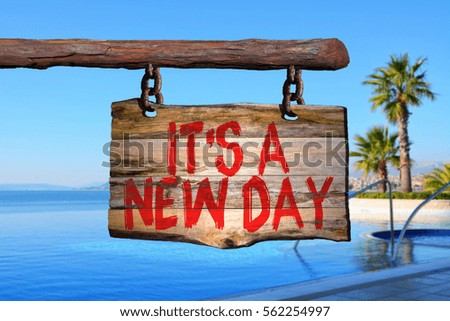 It's a new day motivational phrase sign on old wood with blurred background
