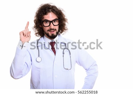 Studio shot of happy man doctor smiling and pointing finger up