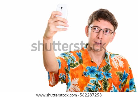 Studio shot of man taking selfie picture with mobile phone