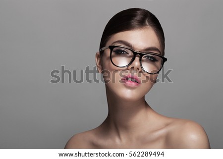 woman in glasses over grey background