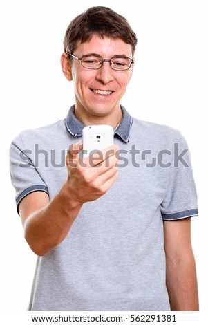 Studio shot of happy man smiling while holding mobile phone