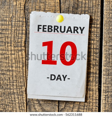 February 10th. Day 10 of month calendar in notepad on wooden background