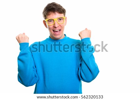 Studio shot of happy man smiling while looking excited with both arms raised