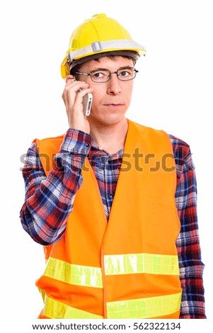 Studio shot of thoughtful man construction worker talking on mobile phone